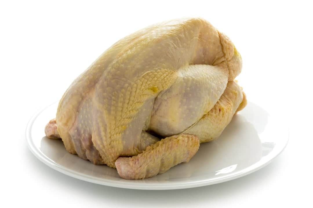 Whole slaughtered and cleaned Kienyeji chicken on a plate